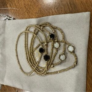 Set of 6 gold stretch bracelets with white and black stones.